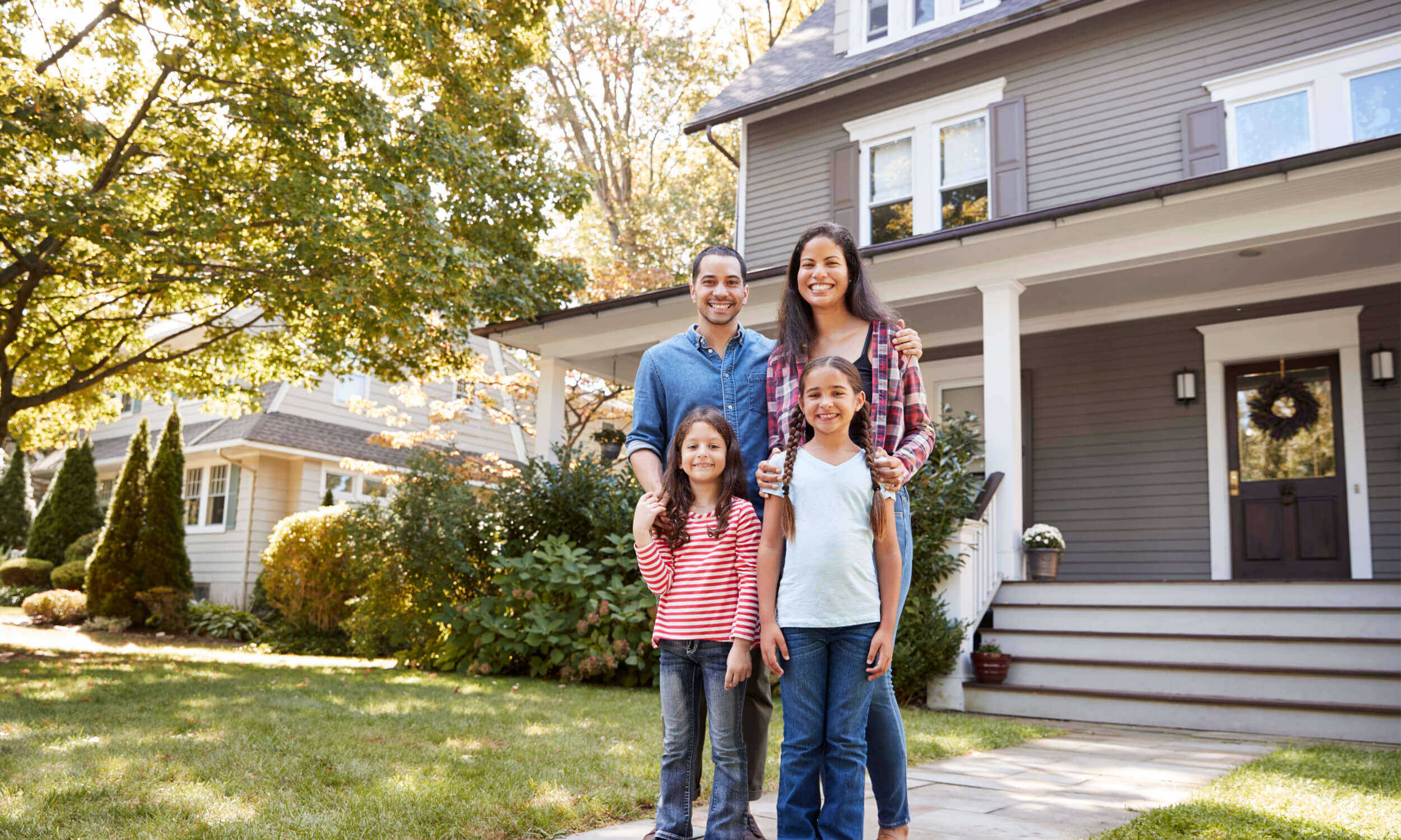 Image of happy family in from of their home.